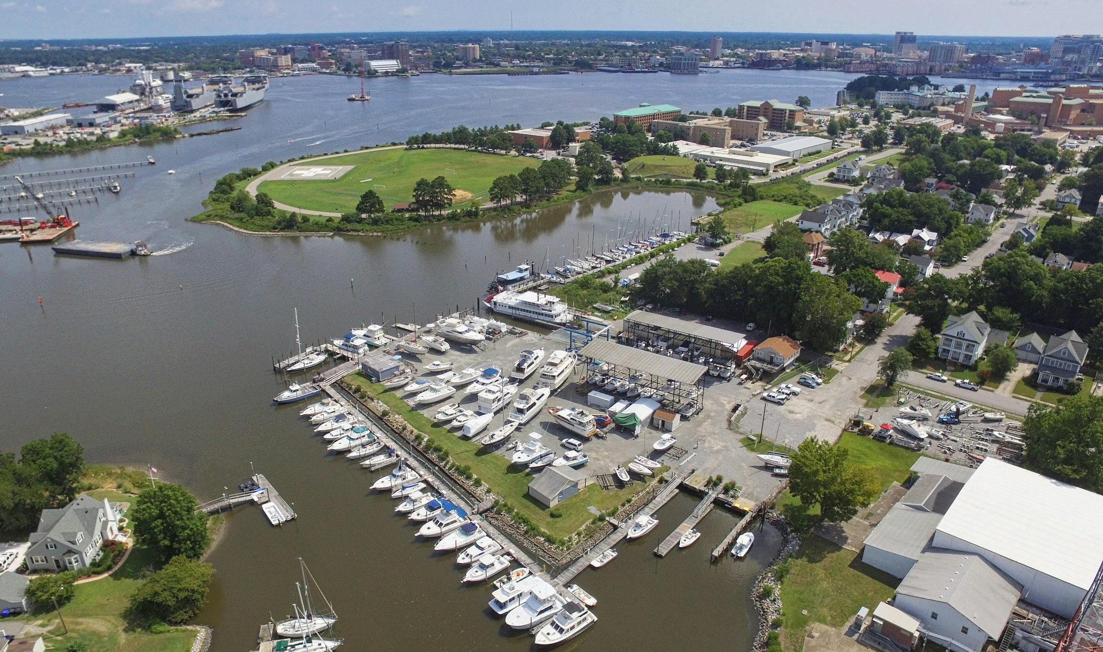 Aerial view of a small independent marina with docks, a boatyard, and boats in slips