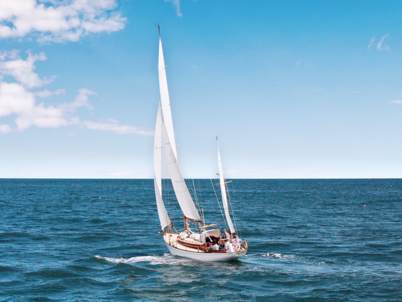 Sailboat under full sail on open blue water